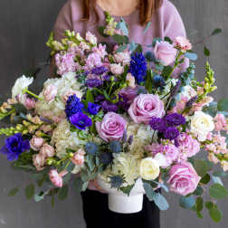 Large mixed bouquet in a white vase with pink, white, and purple flowers