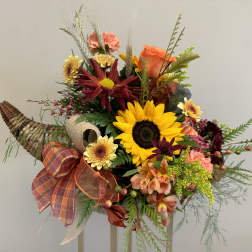 Autumn bouquet with sunflowers, roses, and mixed blooms in a woven cornucopia container