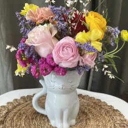 Colorful bouquet in a white cat-shaped mug vase