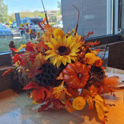 Autumn floral centerpiece with sunflowers, pumpkins, and fall leaves