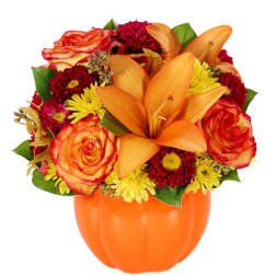 Orange lilies and roses in a pumpkin-shaped vase