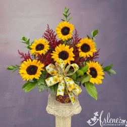 Sunflower arrangement in a decorative vase with a sunflower ribbon