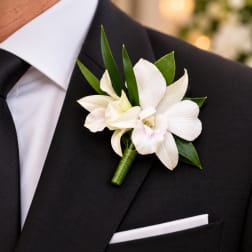 White orchid boutonniere on a black suit jacket