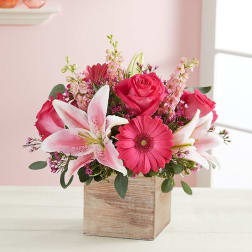 Pink roses and lilies arranged in a wooden box