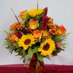 Bouquet of yellow sunflowers and orange roses in a glass vase