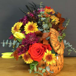 Autumn bouquet with roses, chrysanthemums, and a pumpkin vase