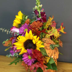 Autumn bouquet with sunflowers, purple daisies, and a decorative pumpkin