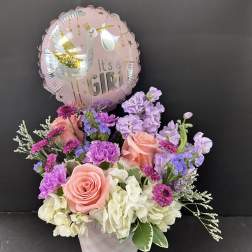Pink and lavender flower arrangement with a "It's a Girl" balloon