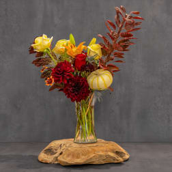 Autumn bouquet of red and yellow flowers in a clear glass vase