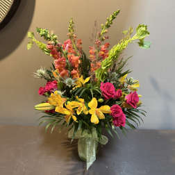 Bright mixed bouquet in a glass vase with pink roses and yellow blooms