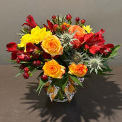 Mixed bouquet of red and yellow flowers in a glass vase