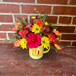 Bouquet of pink, yellow, and coral flowers in a yellow mug