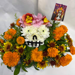 Floral arrangement shaped like a skull with a decorative card on top