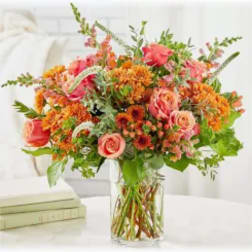 Orange and pink mixed bouquet in a clear glass vase