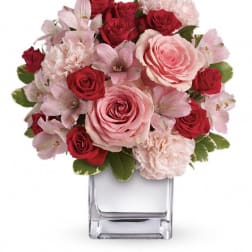 Pink and red rose bouquet in a clear square vase
