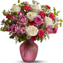 Pink and white rose bouquet in a frosted pink vase