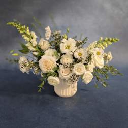 Creamy white bouquet in a ribbed vase with roses and daisies