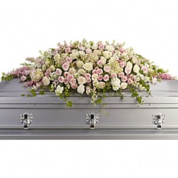 Pastel pink and white floral spray on a silver casket