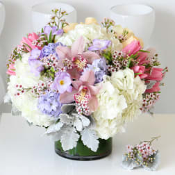 Mixed pastel bouquet in a glass vase with a matching boutonniere