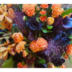 Orange and black floral arrangement with orchids and roses