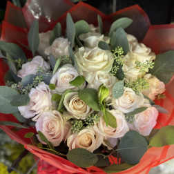 Bouquet of pale roses wrapped in red paper
