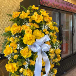 Large yellow floral wreath with a white ribbon bow