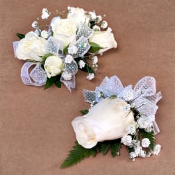 White rose corsages with baby's breath and silver ribbon