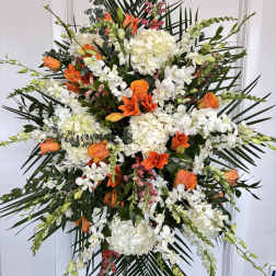 Large standing floral spray with white and orange flowers on a black easel