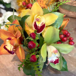 Bouquet of yellow and orange orchids with red berry accents