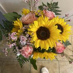 Bouquet of sunflowers, pink roses, and small pink filler flowers