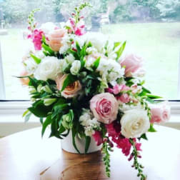 Pink and white rose bouquet in a white vase