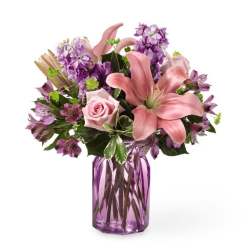 Pink lilies and roses in a purple glass vase