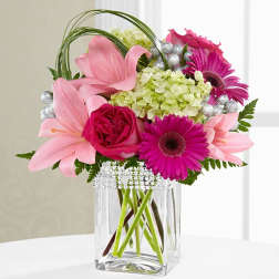 Pink lilies and magenta gerbera daisies in a clear glass vase