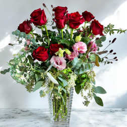 Red roses and pink lisianthus in a clear glass vase