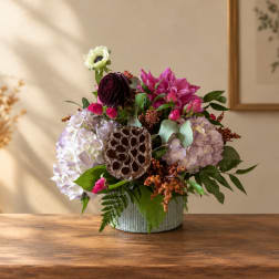 Mixed bouquet in a ribbed metal vase with hydrangeas and bright pink blooms