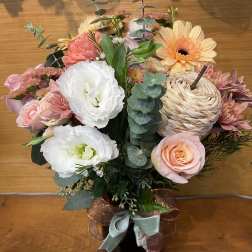 Pink and white mixed flower arrangement in a black vase with ribbon