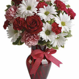 Bouquet of red roses, white daisies, and pink carnations in a red vase