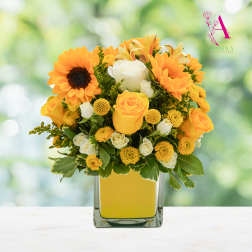 Yellow and white flowers arranged in a square glass vase