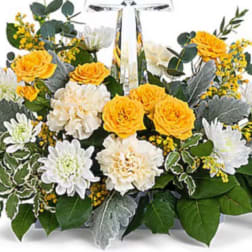 Yellow and white flower arrangement with a clear cross centerpiece