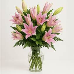 Pink lilies arranged in a clear glass vase