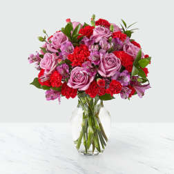 Pink roses and red carnations in a clear glass vase