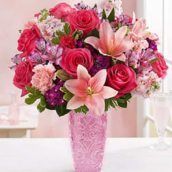Pink roses and lilies arranged in a pink vase
