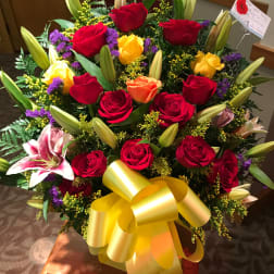 Large bouquet of red and yellow roses with lilies and a yellow bow