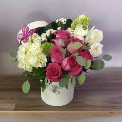 Pink and white rose arrangement in a white hatbox