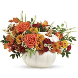 Orange and yellow floral arrangement in a white pumpkin-shaped vase