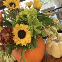 Sunflower and mixed fall bouquet arranged in a pumpkin vase