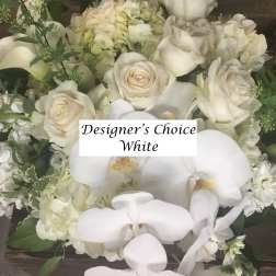 White roses and orchids in a dense floral arrangement