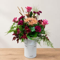 Mixed bouquet in a white metal bucket with pink and burgundy flowers