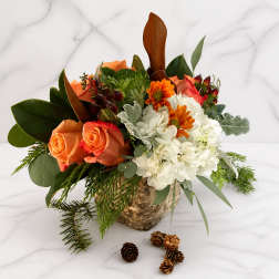 Orange roses and white chrysanthemums in a birch bark container with pinecones