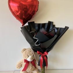 Red heart balloon with teddy bear and wrapped bouquet